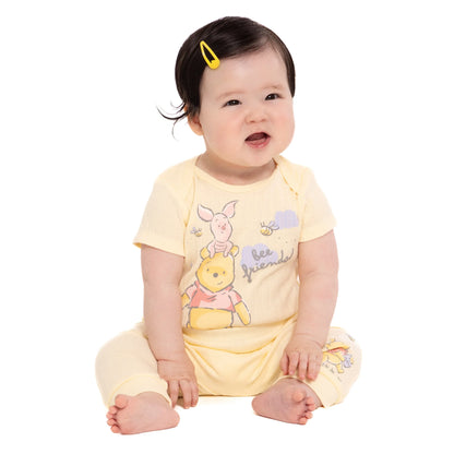Baby wearing a yellow outfit with cartoon character on a white background