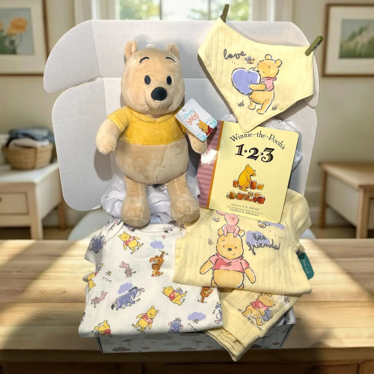 Collection of Winnie the Pooh-themed baby items including a plush toy, blanket, and book on a chair.