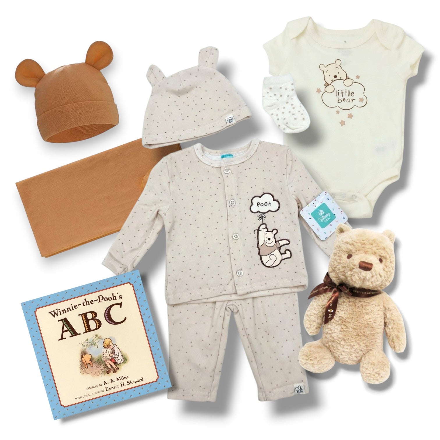 Collection of baby clothing and toys with 'Winnie the Pooh' theme on a white background