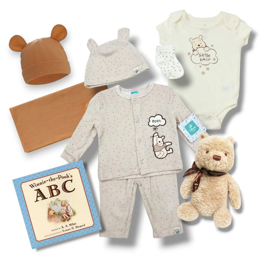 Collection of baby clothing and toys with 'Winnie the Pooh' theme on a white background