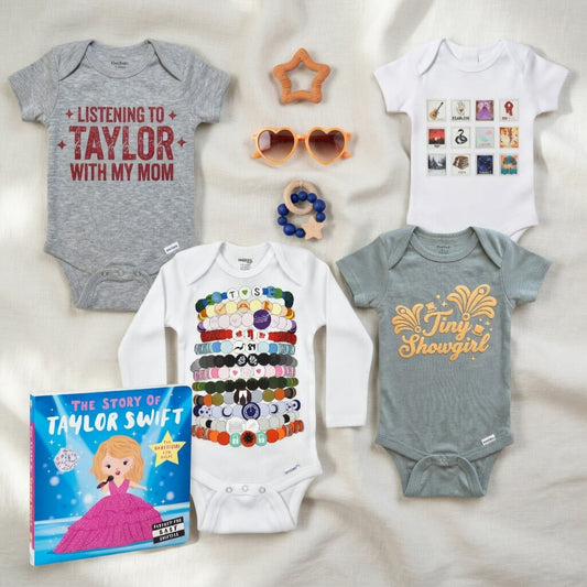 Collection of baby onesies, sunglasses, and a book on a light background