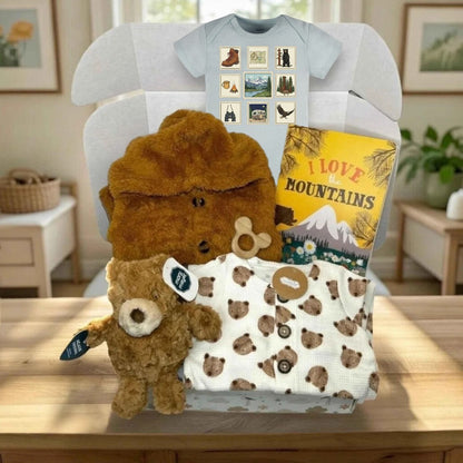 Baby gift set with teddy bear, t-shirt, and blanket on a table.