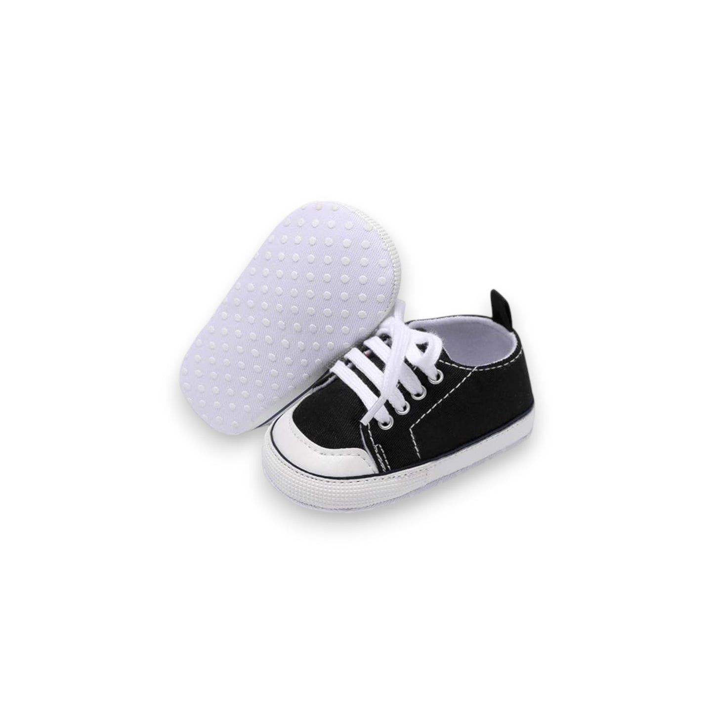 Black and white baby shoe with sole showing texture on a white background